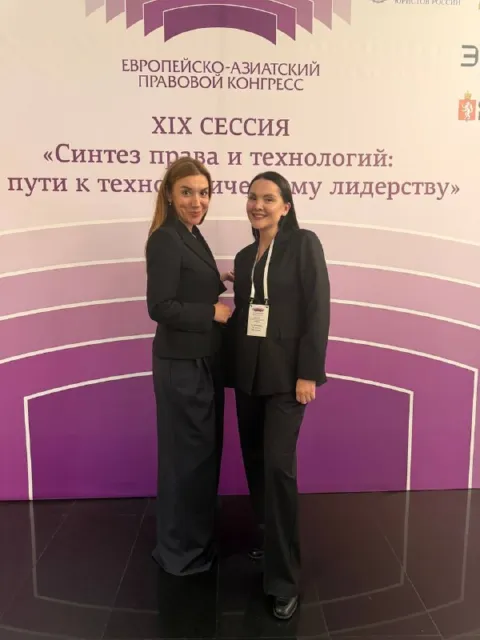 ЕАПК 2026: Ксения (справа, бейдж) с коллегой у пресс-волла XIX сессии «Синтез права и технологий»
