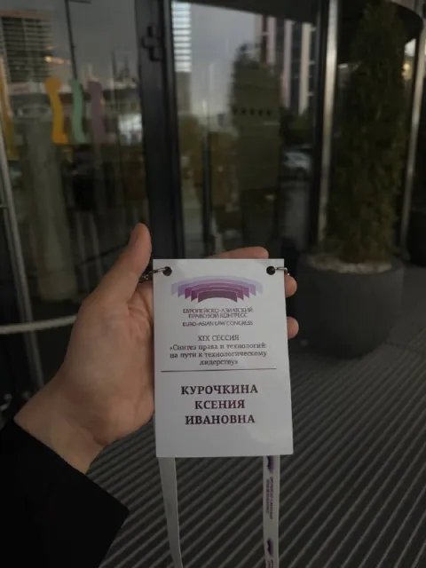 ЕАПК 2026: бейдж участника «Курочкина Ксения Ивановна» в руке у входа